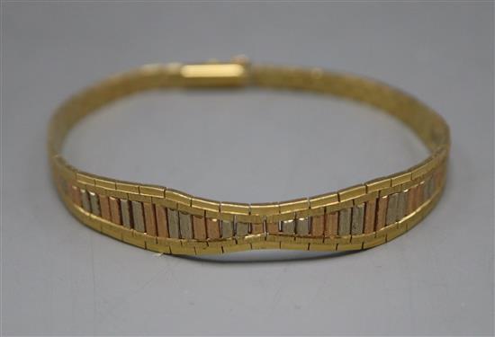 A three-colour yellow metal (tests as 18ct) flexible baton bracelet, gross 18 grams.